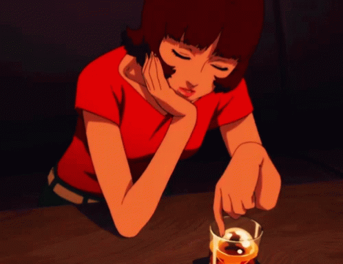 A Woman In A Red Shirt Sits At A Table With A Glass Of Whiskey In Front Of Her GIF