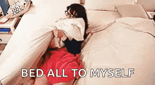 A Woman In A Red Skirt Is Laying On A Bed With The Words `` Bed All To Myself '' Above Her . GIF