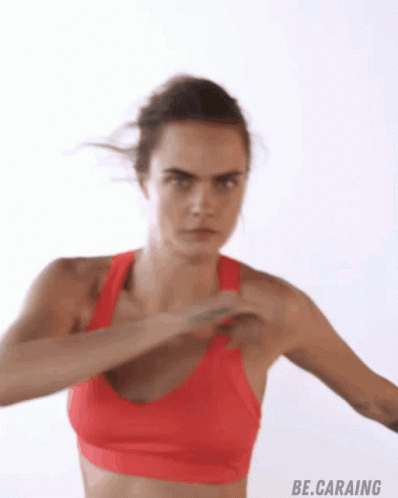 A Woman In A Red Sports Bra Is Doing A Fist Pump GIF