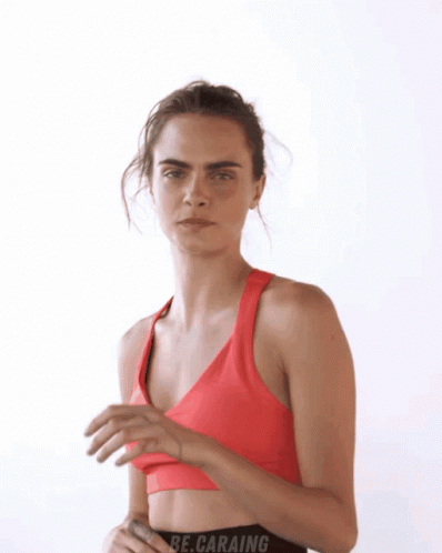 A Woman In A Red Sports Bra With The Word Be.caraing On The Bottom GIF