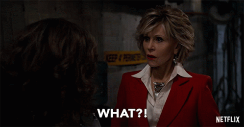 A Woman In A Red Suit And White Shirt Says What GIF