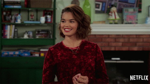 Woman In Red Sweater Smiling In Front Of Fireplace GIF