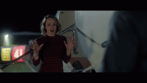 A Woman In A Red Sweater Stands In Front Of A Sign That Says 41 GIF