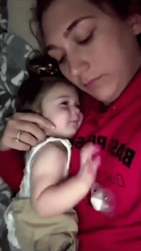 A Woman In A Red Sweatshirt Holds A Baby GIF