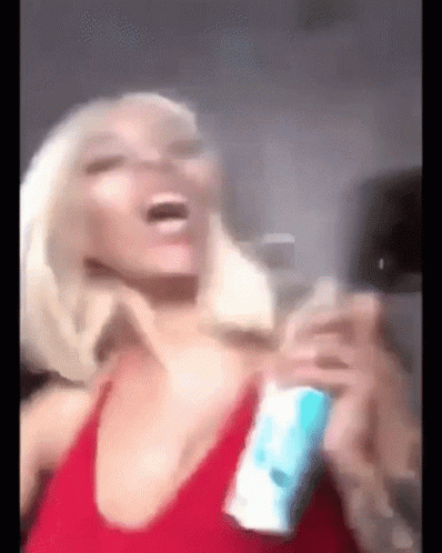 A Woman In A Red Tank Top Is Laughing And Holding A Can Of Soda . GIF