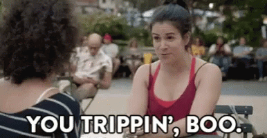 A Woman In A Red Tank Top Is Sitting At A Table With Another Woman . GIF