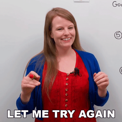 A Woman In A Red Top And Blue Cardigan Is Holding A Red Flower And Says Let Me Try Again GIF