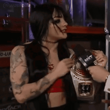 A Woman In A Red Top Is Being Interviewed By A Man With A Microphone That Says Ant On It GIF