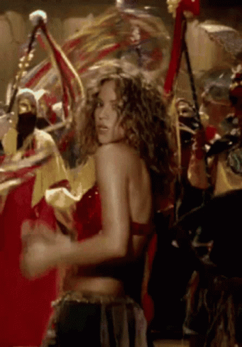 A Woman In A Red Top Is Dancing In A Crowd Of People GIF