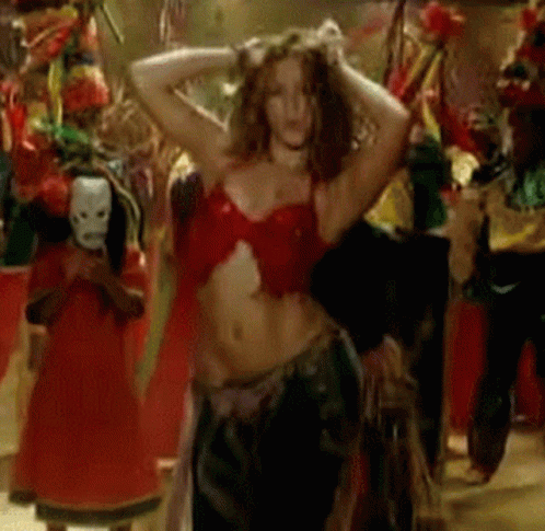 A Woman In A Red Top Is Dancing In A Crowd Of People GIF