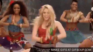 a woman in a red top is dancing with a group of women .