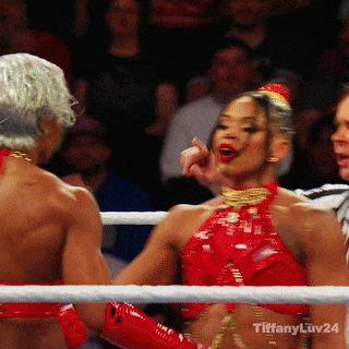 A Woman In A Red Top Is Standing In A Boxing Ring With Tiffany Luv24 Written On The Bottom GIF