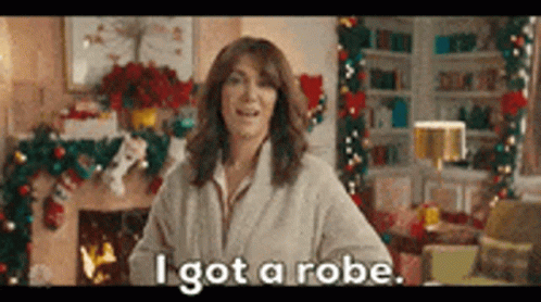 Woman In Robe Standing By Fireplace GIF