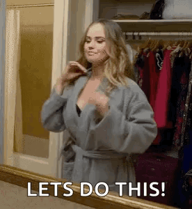 A Woman In A Robe Is Standing In Front Of A Mirror And Saying `` Lets Do This ! '' GIF