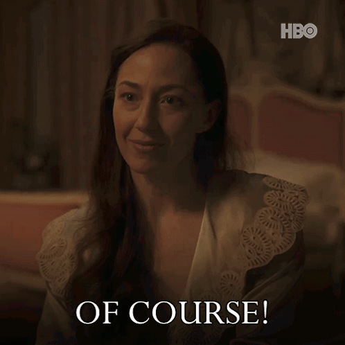 A Woman In A Robe Says " Of Course " In A Dark Room GIF