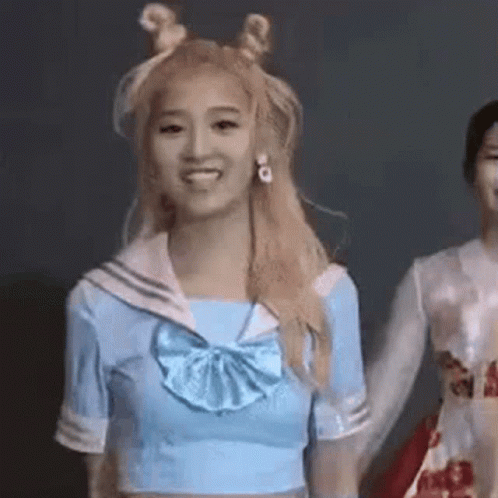 A Woman In A Sailor Suit Is Holding Hands With Another Woman In A White Dress . GIF