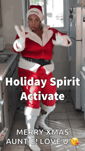 A Woman In A Santa Suit Is Dancing In A Kitchen GIF