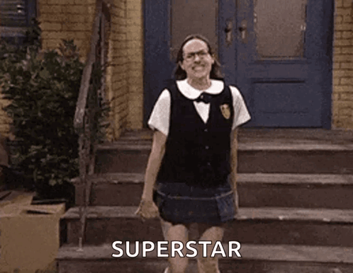 A Woman In A School Uniform Is Standing On A Set Of Stairs In Front Of A Blue Door . GIF