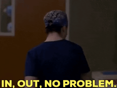 A Woman In A Scrub Top Is Standing In Front Of A Door And Says In Out No Problem GIF