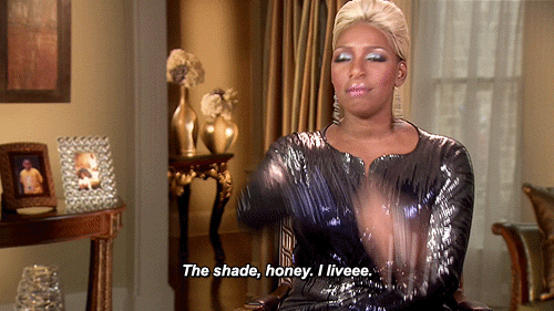 A Woman In A Sequined Dress Is Sitting In A Chair And Says The Shade Honey I Liveee GIF