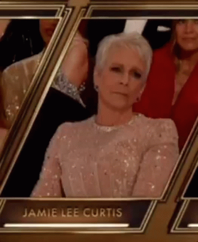 A Woman In A Sequined Dress Is Sitting In A Row Of Frames At An Event . GIF