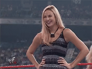 A Woman In A Sequined Dress Is Standing In A Wrestling Ring . GIF