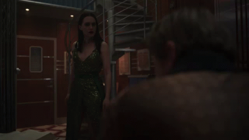 A Woman In A Sequined Dress Stands Next To A Man GIF