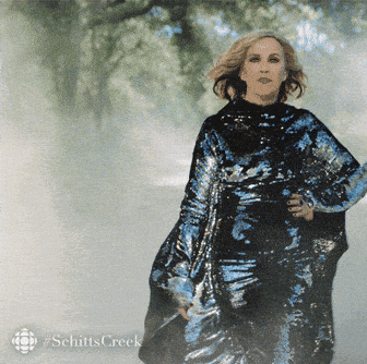 A Woman In A Sequined Dress With The Word Schitts Creek On The Bottom Left GIF