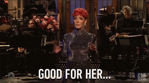 A Woman In A Sequined Top Stands In Front Of An Orchestra And Says " Good For Her " GIF