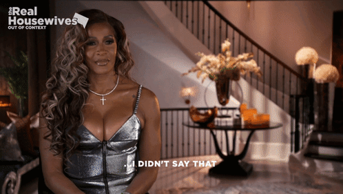 A Woman In A Silver Dress Says I Did N't Say That In Front Of A Staircase GIF