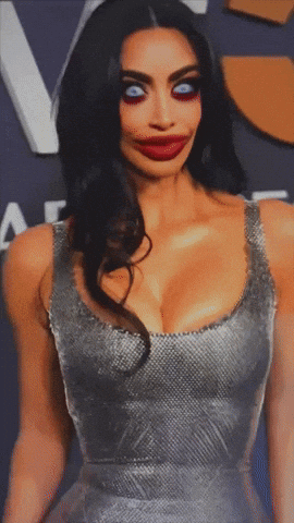 A Woman In A Silver Dress With A Big Red Lip Looks Very Strange GIF