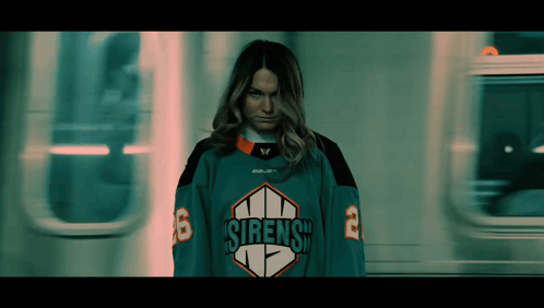 A Woman In A Sirens Jersey Is Standing In Front Of A Train GIF