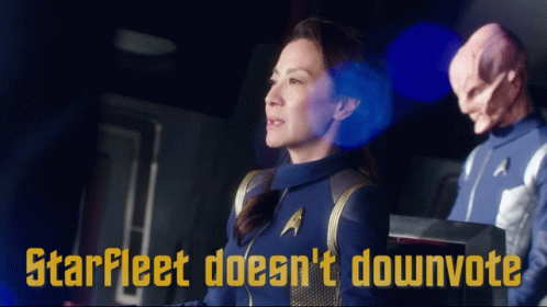 A Woman In A Star Fleet Uniform Stands Next To A Man In A Star Trek Uniform GIF