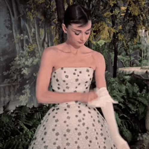 Woman In Strapless Dress Putting On Gloves GIF