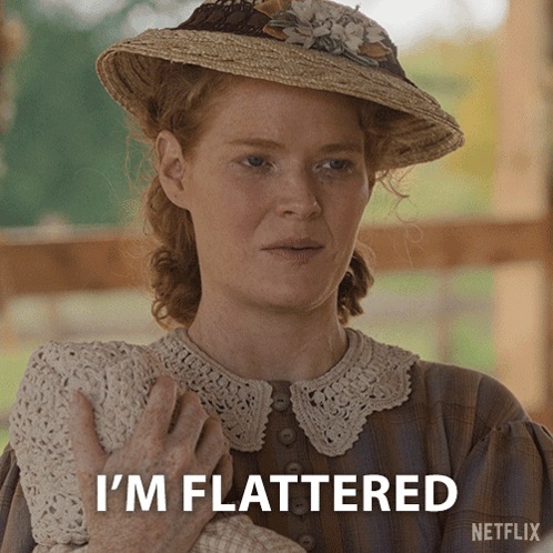 A Woman In A Straw Hat Holds A Baby And Says " I 'M Flattered " GIF
