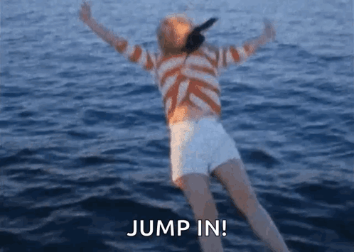 A Woman In A Striped Shirt And White Shorts Is Jumping In The Water . GIF
