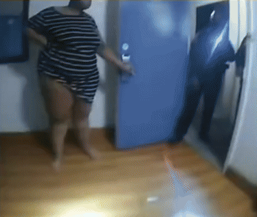 a woman in a striped shirt stands in front of a door
