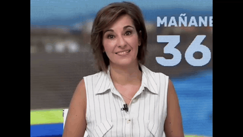 a woman in a striped shirt stands in front of a sign that says mañana 36