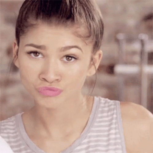 A Woman In A Striped Tank Top With Pink Lipstick On Her Lips GIF