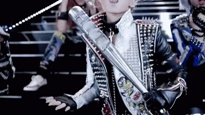 A Woman In A Studded Jacket Holds A Metal Bat GIF