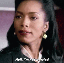 A Woman In A Suit And Earrings Is Talking About Not Being Worried . GIF
