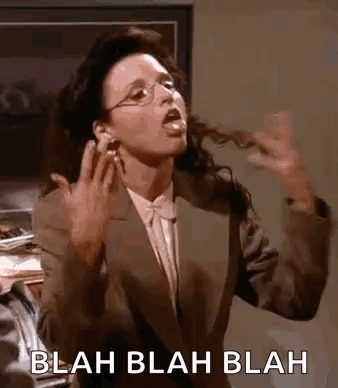 A Woman In A Suit And Glasses Is Making A Funny Face And Sticking Her Tongue Out . GIF