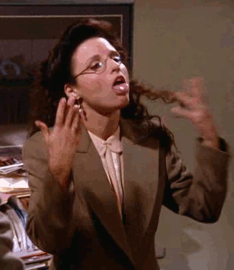 A Woman In A Suit And Glasses Is Sticking Her Tongue Out And Making A Funny Face . GIF