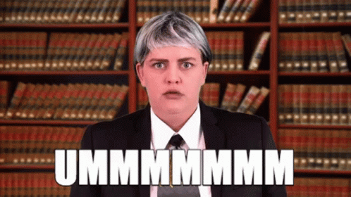 Woman In Suit And Tie In Front Of Bookshelf Says Ummmmmm GIF