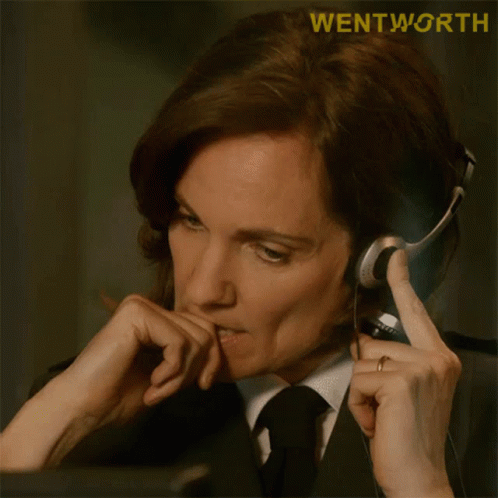 A Woman In A Suit And Tie Is Wearing A Headset With The Word Wentworth On The Bottom GIF