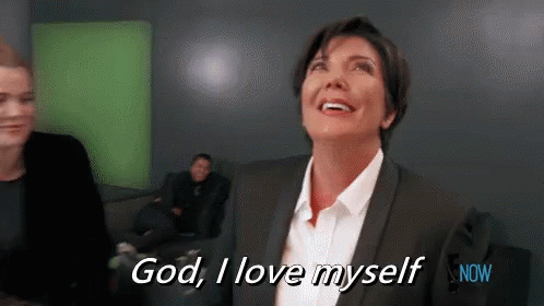 A Woman In A Suit And White Shirt Is Smiling And Saying God , I Love Myself . GIF