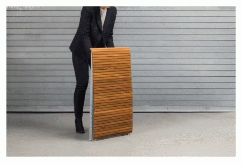 A Woman In A Suit Is Holding A Wooden Plank GIF