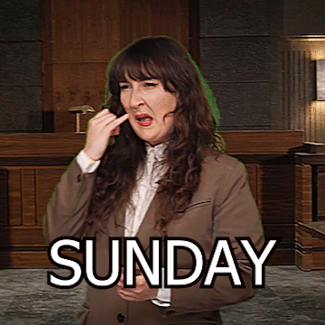 A Woman In A Suit Is Making A Funny Face In Front Of A Sign That Says " Sunday " GIF