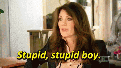 A Woman In A Suit Is Sitting At A Table And Says `` Stupid , Stupid Boy . '' GIF
