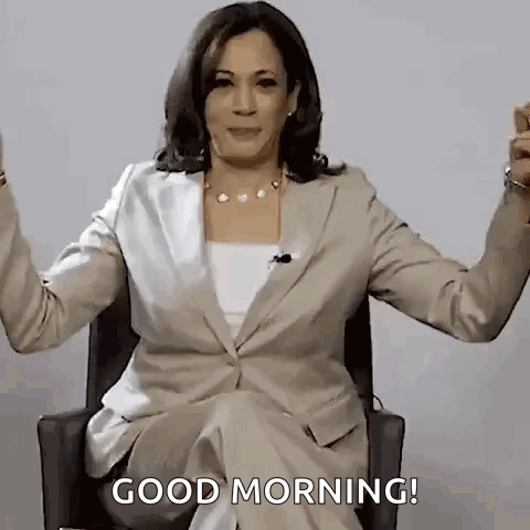 A Woman In A Suit Is Sitting In A Chair With Her Arms Outstretched . GIF